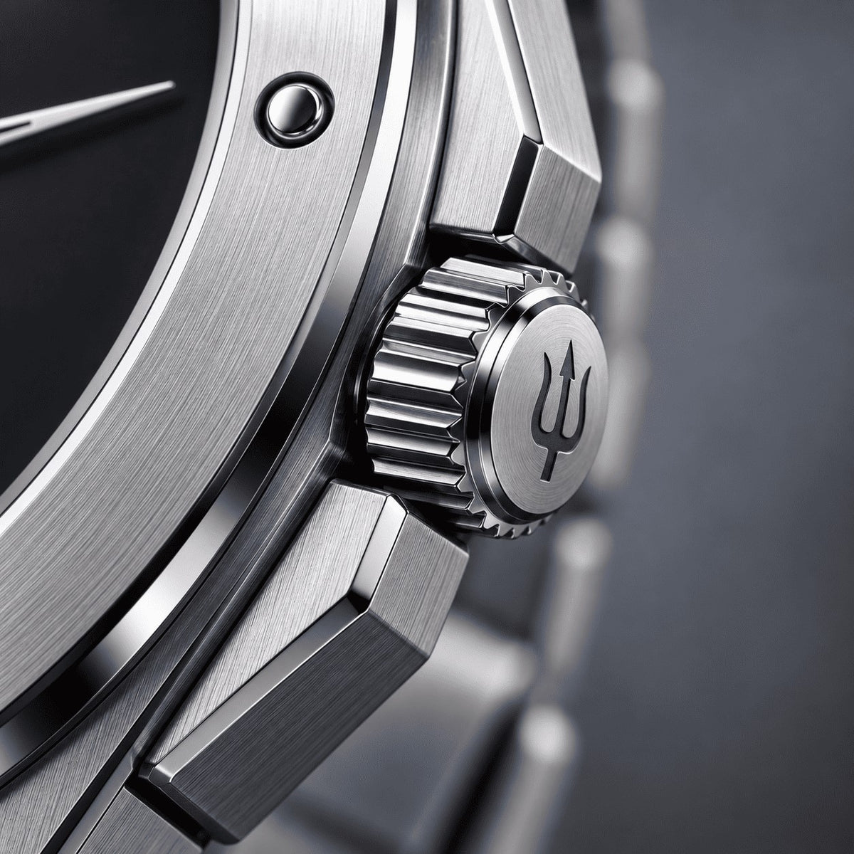 Close-up of the SANDAHL ACHROMATIC Musou crown with trident engraving, beside the black dial and steel case.