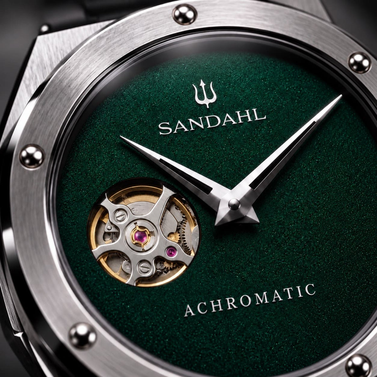 Close-up of the green SANDAHL ACHROMATIC Petrol dial, open-heart aperture, polished hands and trident.