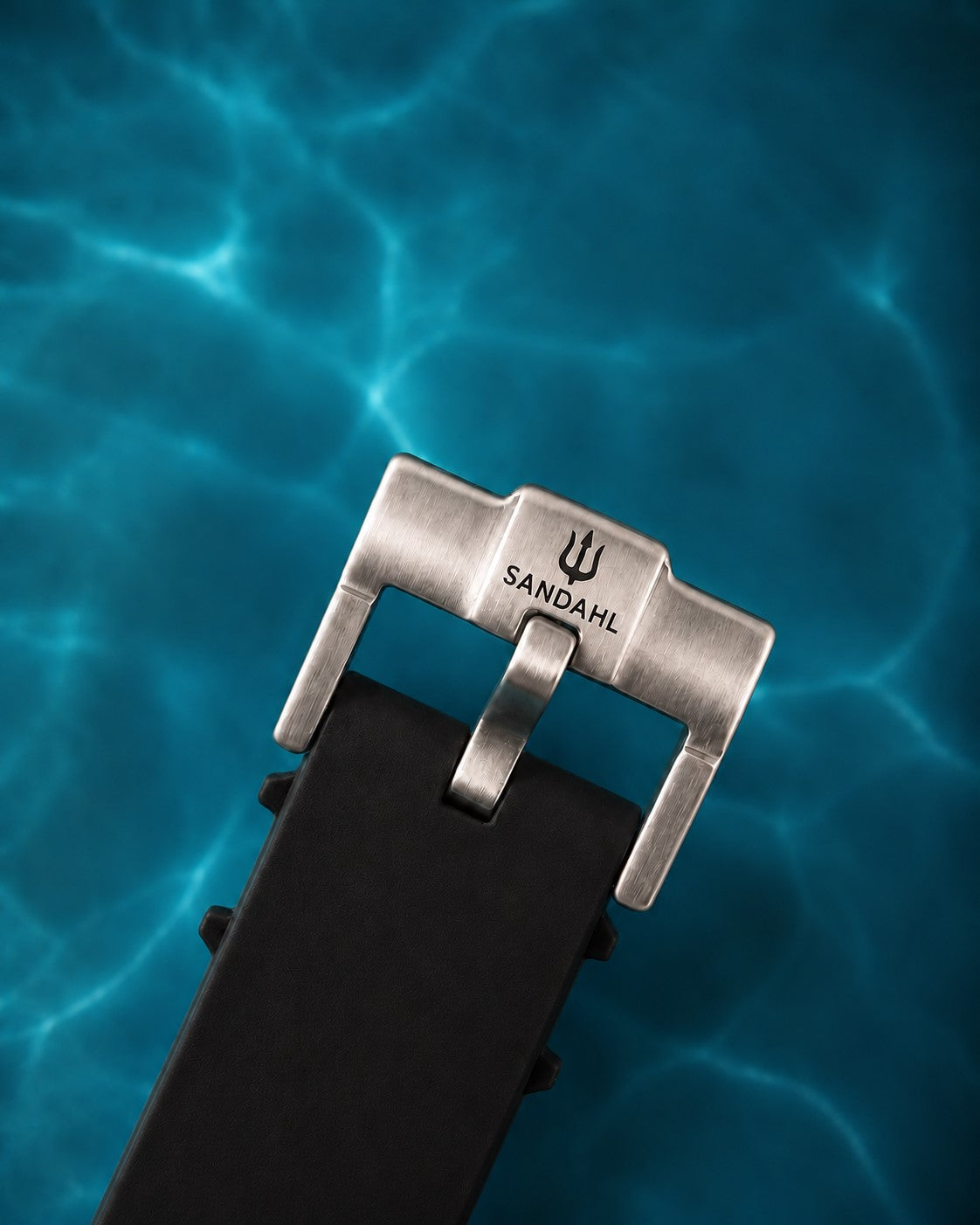 Close-up of the SANDAHL-engraved steel buckle and black rubber strap for AEREUS Patina Teal.