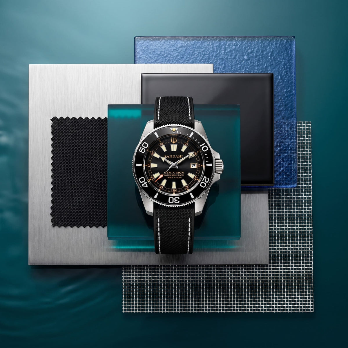 SANDAHL CENTURION black dial watch with a black strap, arranged on layered metal, teal glass and textured material samples.
