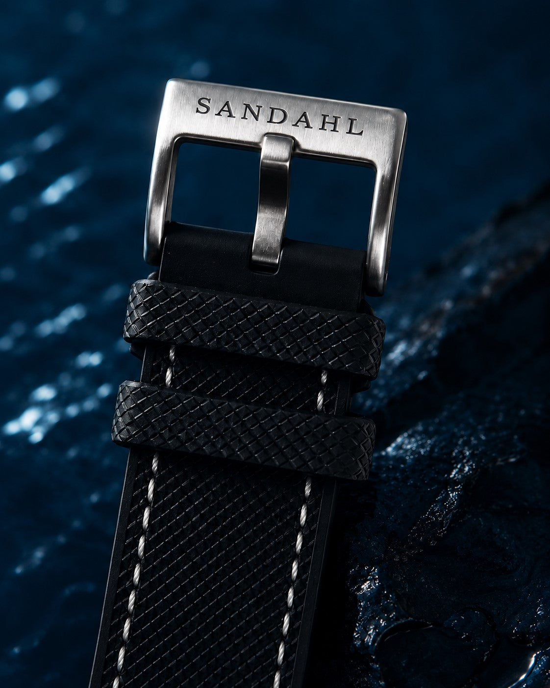 Close-up of the SANDAHL-engraved buckle and black textured strap on CENTURION Blackwater.