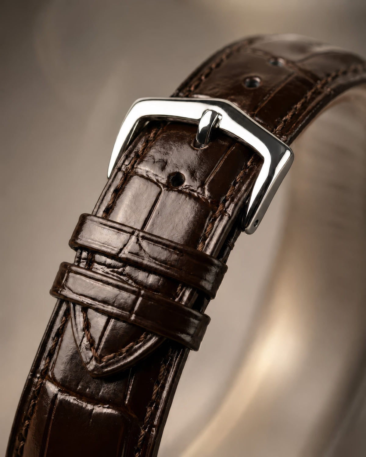 Close-up of the polished buckle and brown crocodile-pattern leather strap on SANDAHL ORNATUS Cobalt.