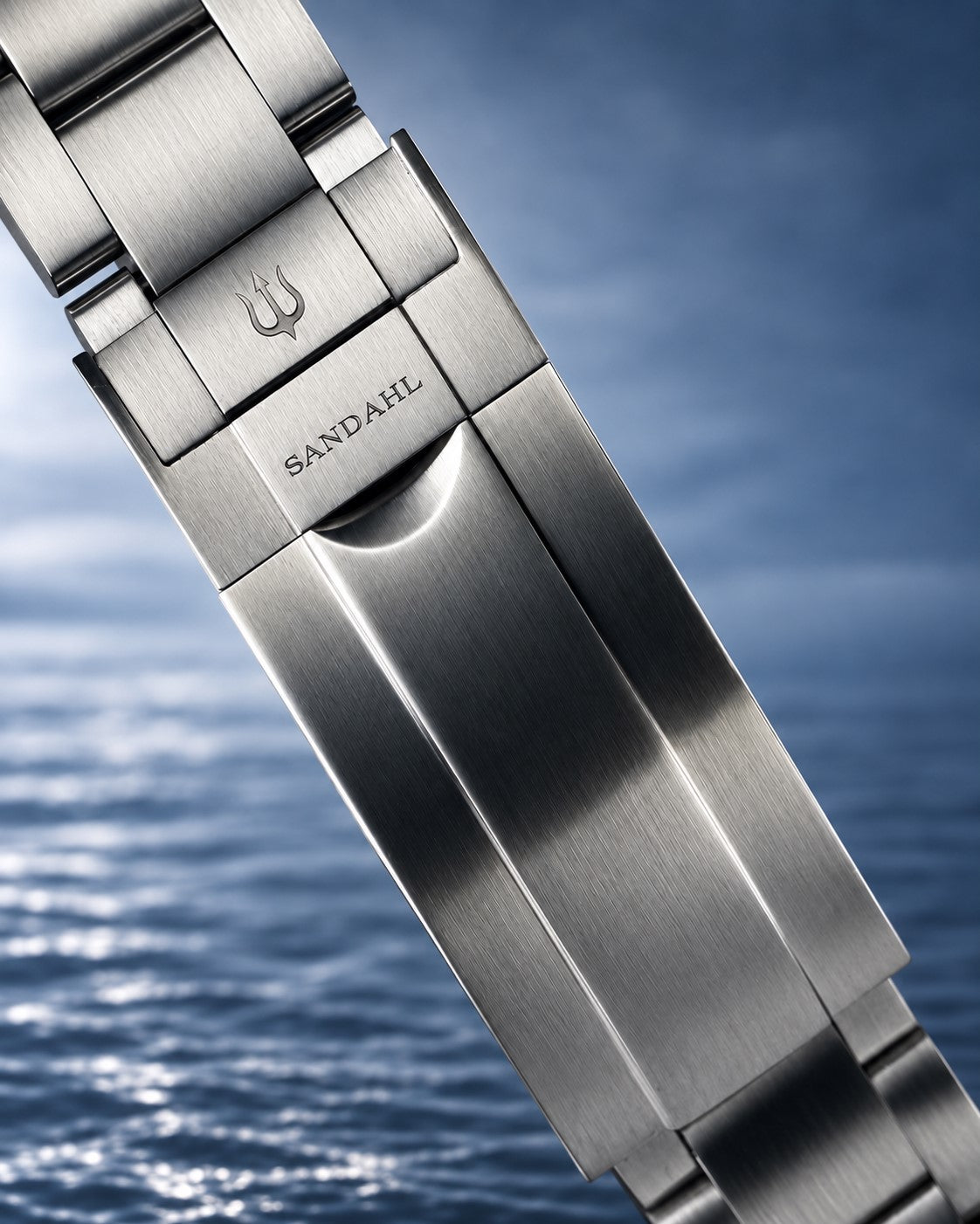 Close-up of a SANDAHL SHALLOW steel bracelet clasp engraved with SANDAHL and the trident.