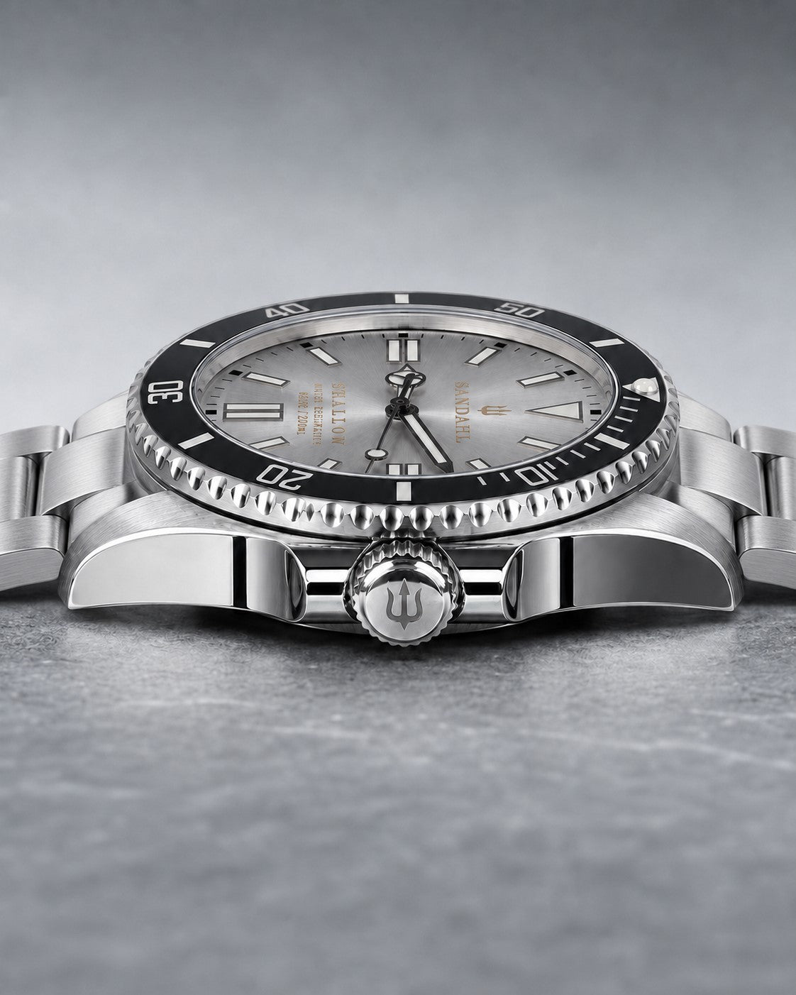 Low angled view of SANDAHL SHALLOW Sea Mist Silver, showing the dial, dive bezel, crown and steel bracelet.