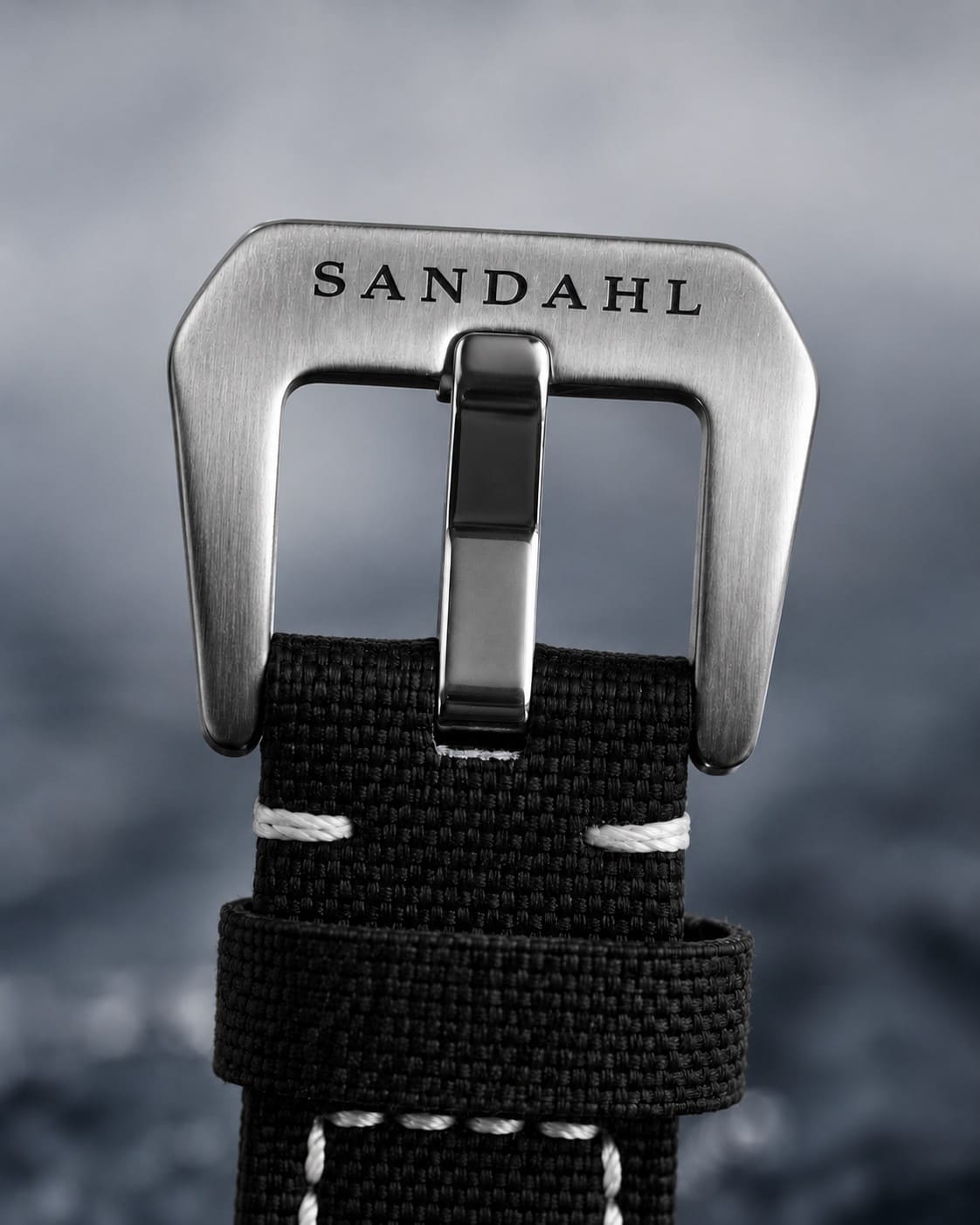 Close-up of the engraved steel buckle and stitched fabric strap on SANDAHL SHALLOW Skagerrak Teal.