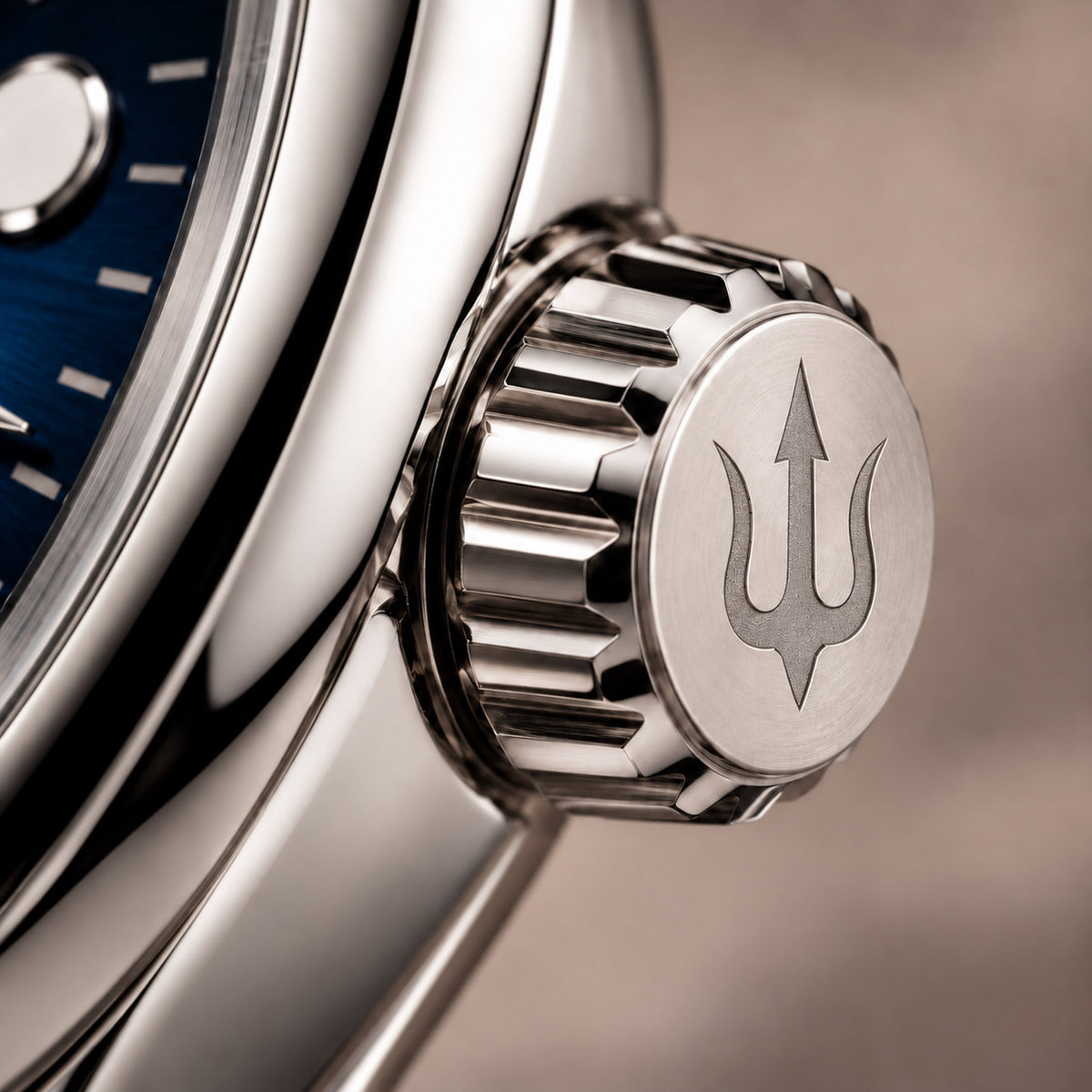 Extreme close-up of the SUITS Midnight Navy stainless steel crown, highlighting its engraved trident symbol and fluted edges.