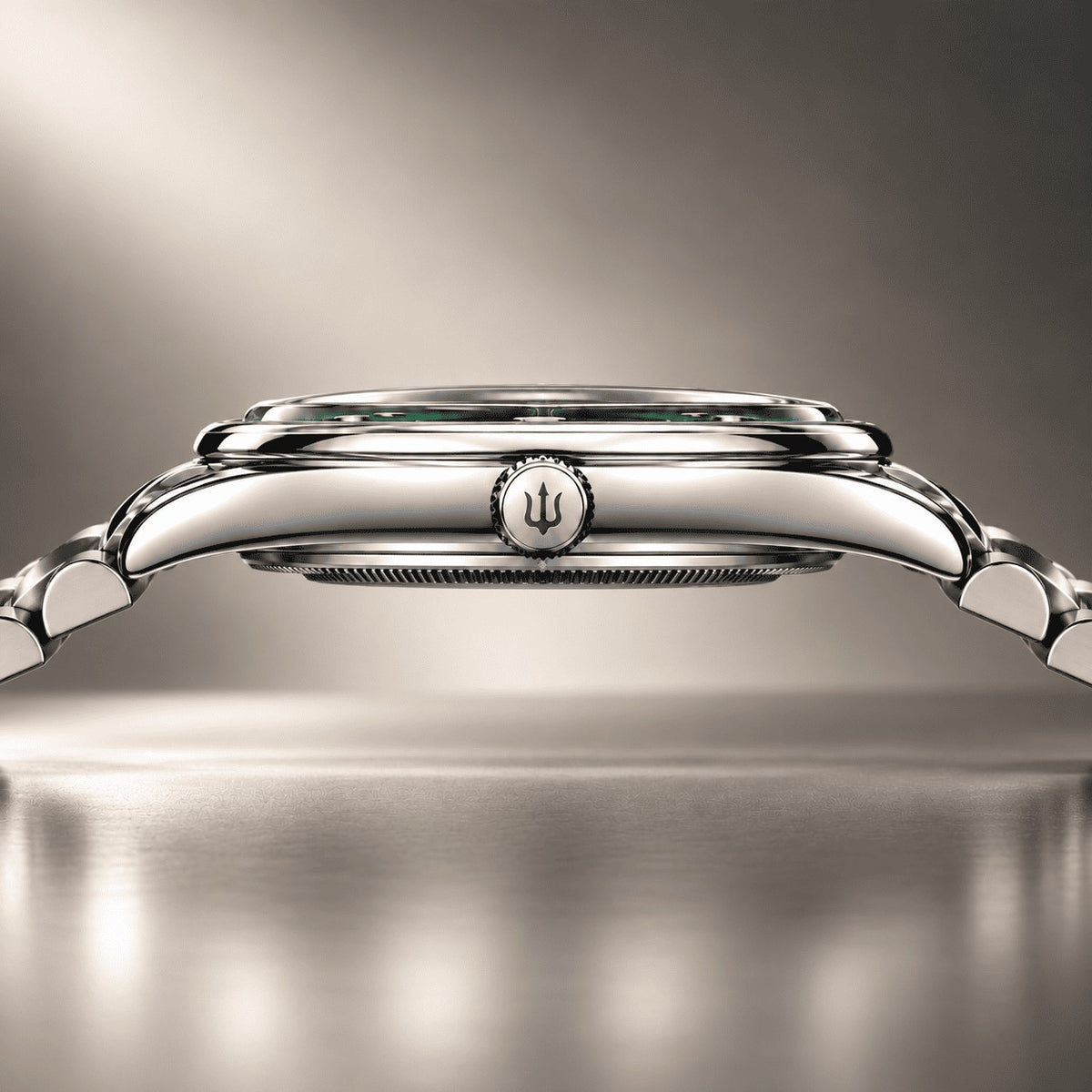 Side profile of a SANDAHL SUITS watch showing the polished crown with trident engraving, rounded case and steel bracelet.