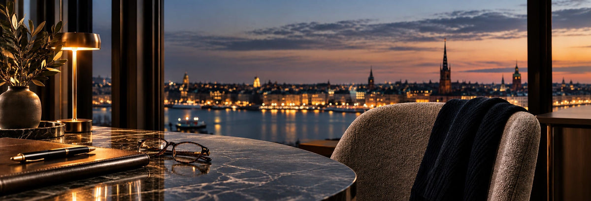 SANDAHL SUITS banner overlooking Stockholm at dusk with an elegant desk and waterfront city view.