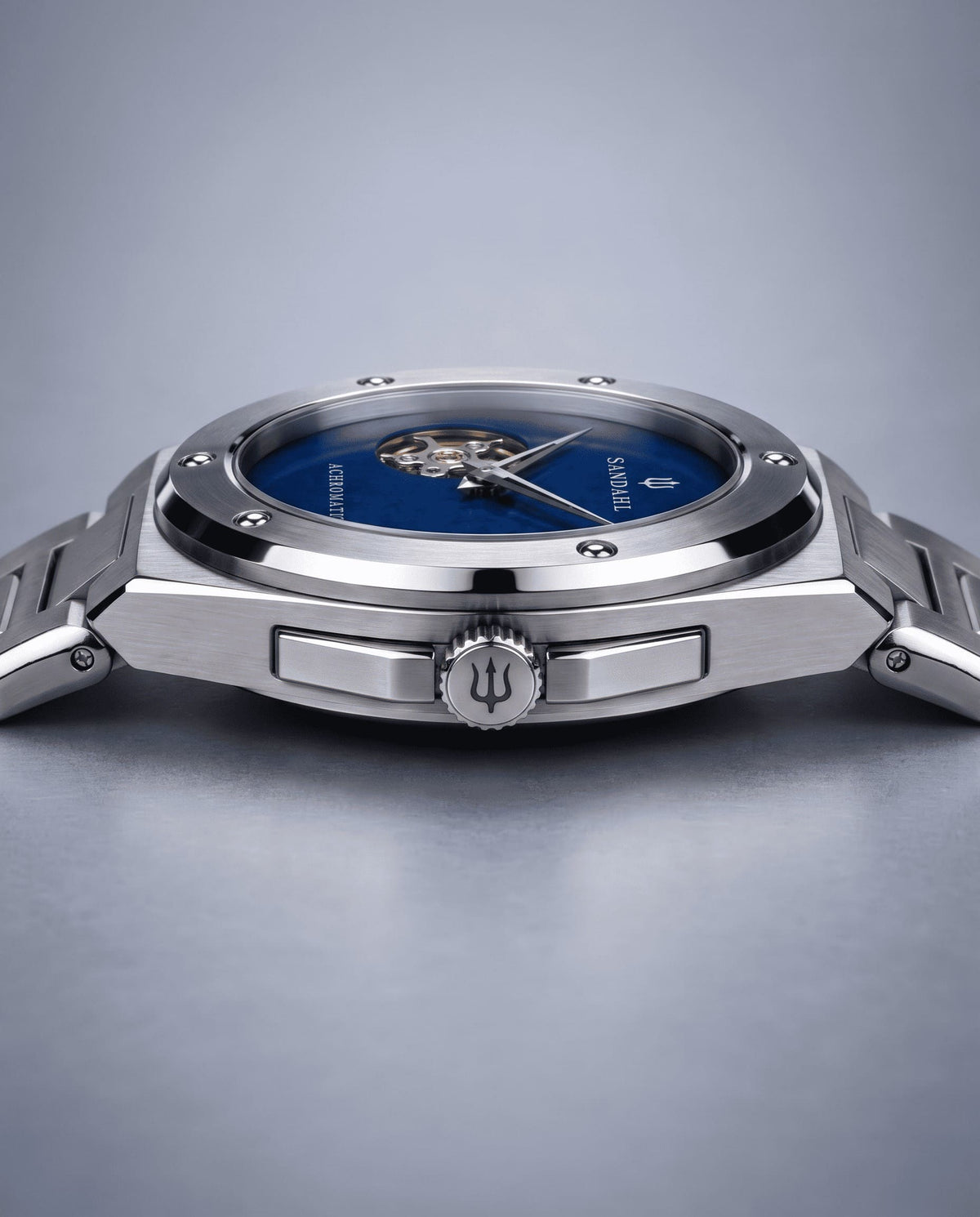 Angled view of the SANDAHL ACHROMATIC Cobalt, showing its blue dial, steel case, crown and steel bracelet.