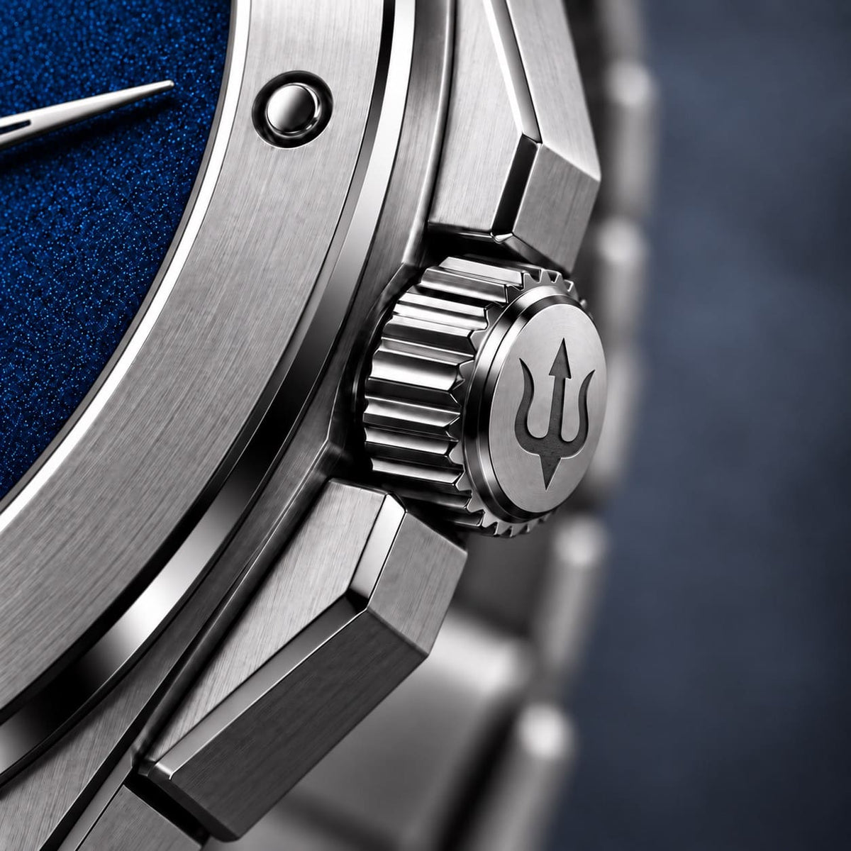 Close-up of the SANDAHL ACHROMATIC crown engraved with a trident beside the blue dial.