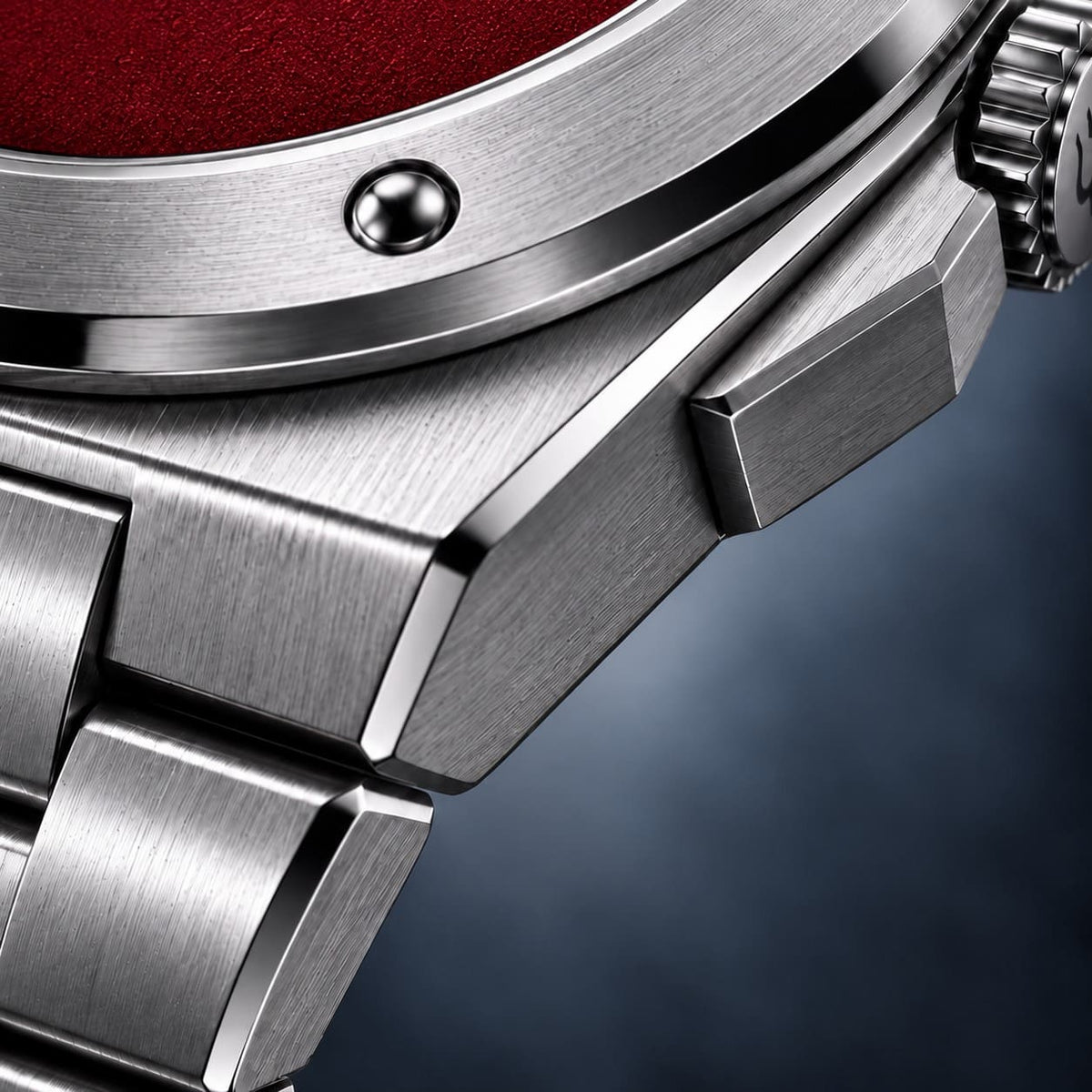 Macro view of the SANDAHL ACHROMATIC Crimson steel case and bracelet beside the red dial.