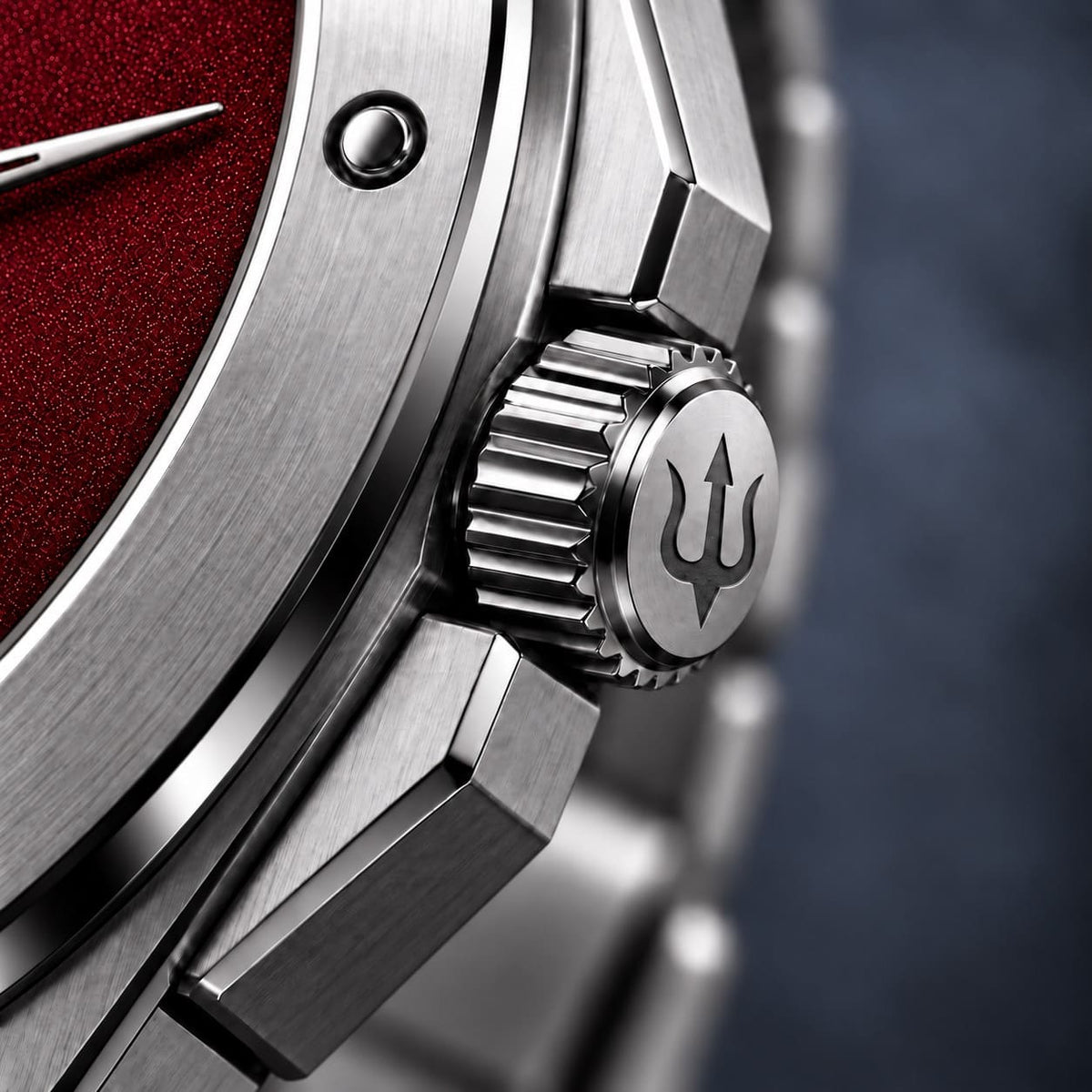 Close-up of the SANDAHL ACHROMATIC crown engraved with a trident beside the red dial.