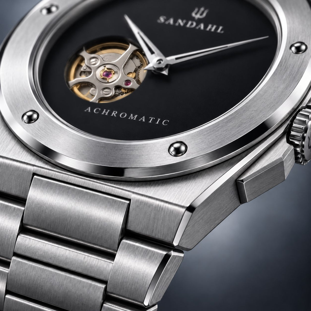 Macro view of the SANDAHL ACHROMATIC Musou steel case and bracelet beside the black dial.