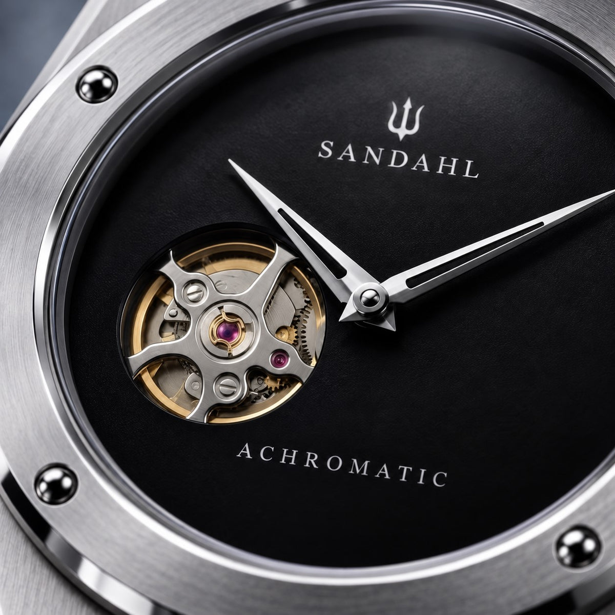 Close-up of the black SANDAHL ACHROMATIC Musou dial, open-heart aperture, polished hands and trident.