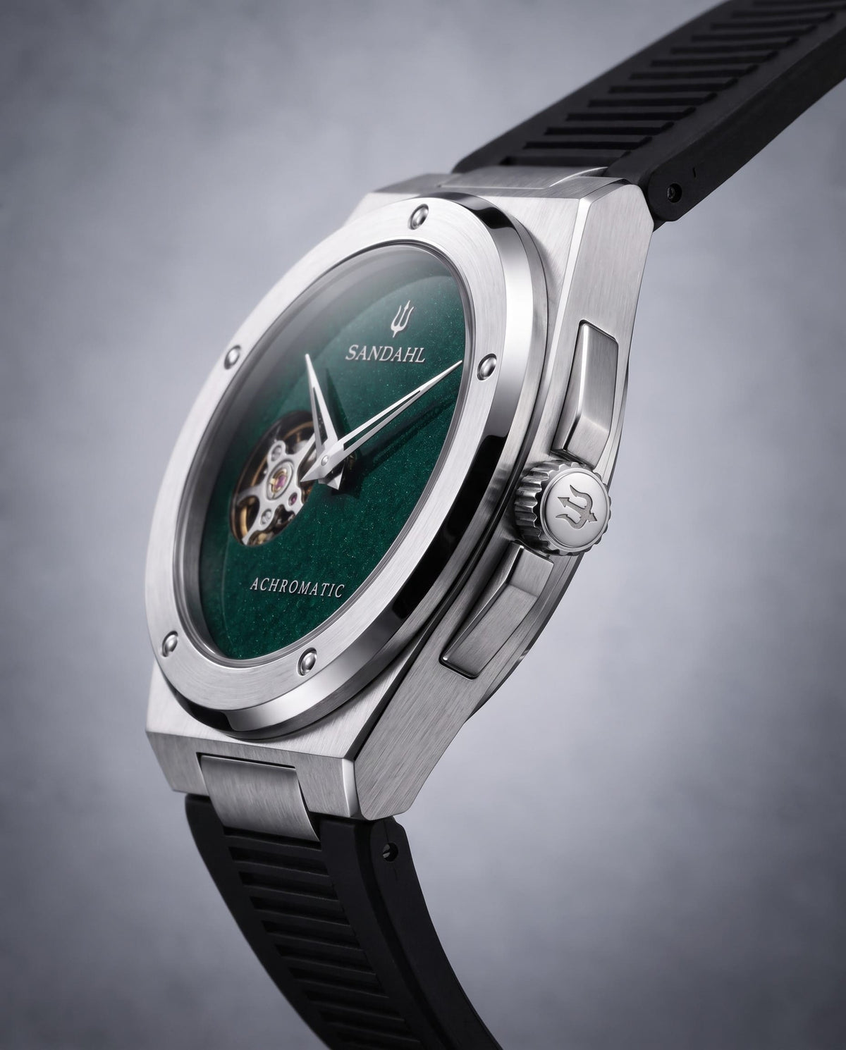 Angled view of the SANDAHL ACHROMATIC Petrol with a green dial, steel case and black rubber strap.