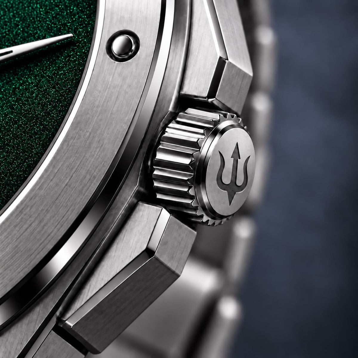 Close-up of the SANDAHL ACHROMATIC crown engraved with a trident beside the green dial.