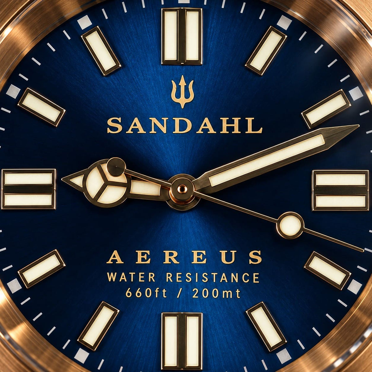 Close-up of the SANDAHL AEREUS ABYSS BLUE sunburst dial with gold-tone hands, luminous indices and a bronze dive bezel.