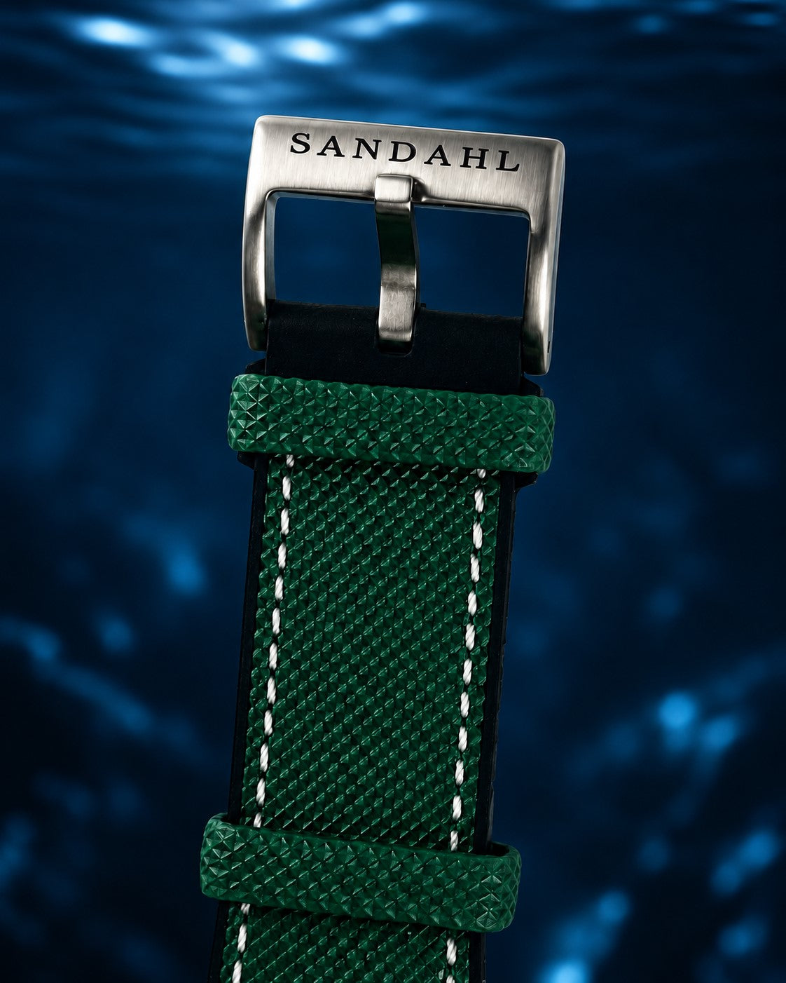 Close-up of the SANDAHL-engraved buckle and green textured strap on CENTURION Trench Green.
