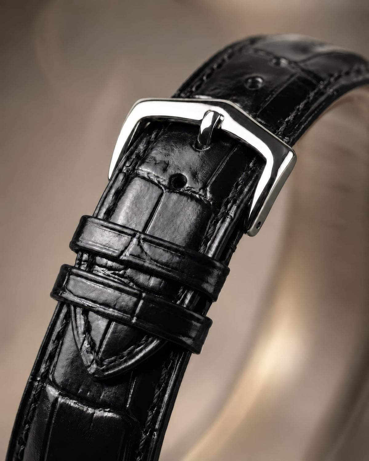 Close-up of the polished buckle and black crocodile-pattern leather strap on SANDAHL ORNATUS Garnet.