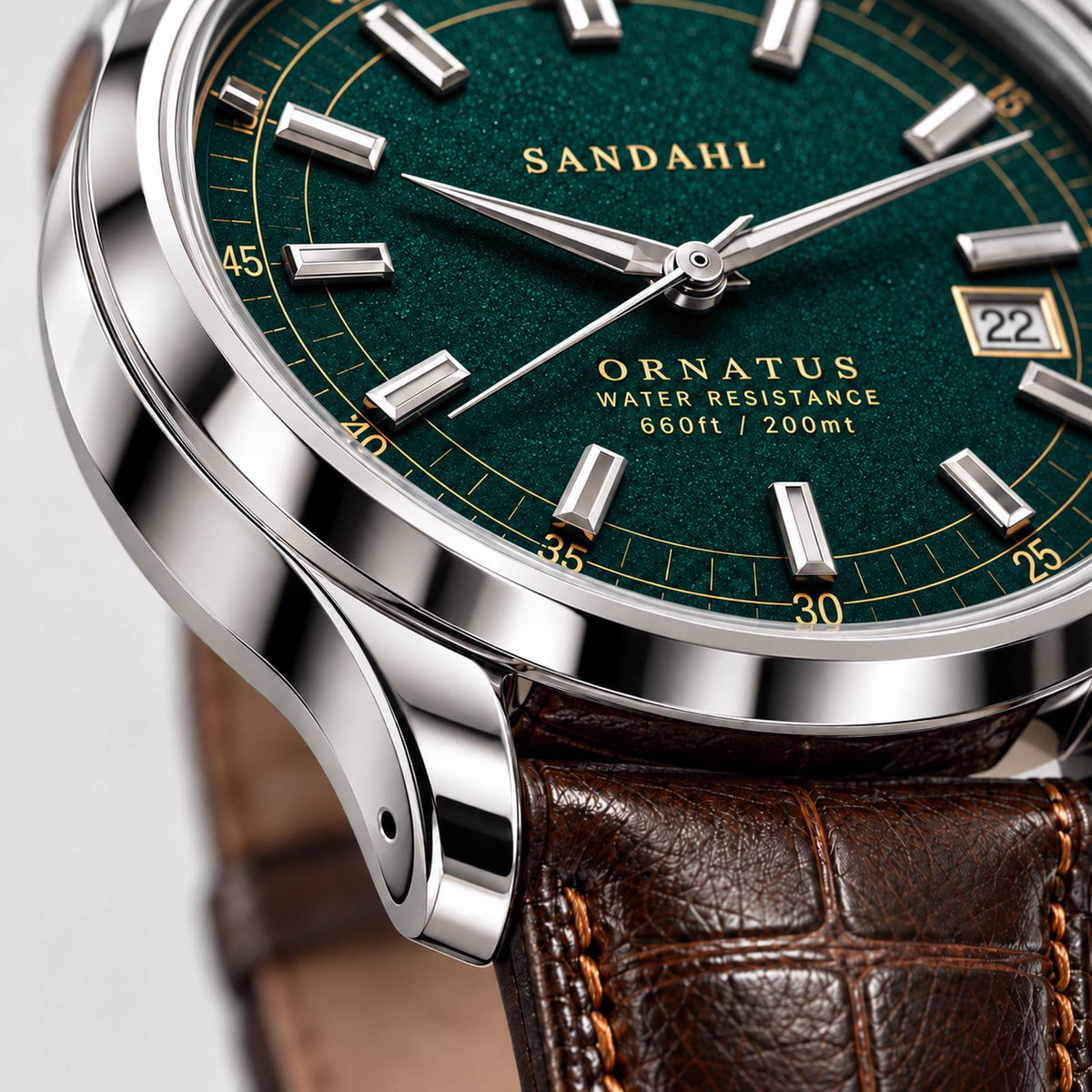 Close-up of the polished steel case and rounded lugs of SANDAHL ORNATUS Malachite, with a green textured dial and brown leather strap.