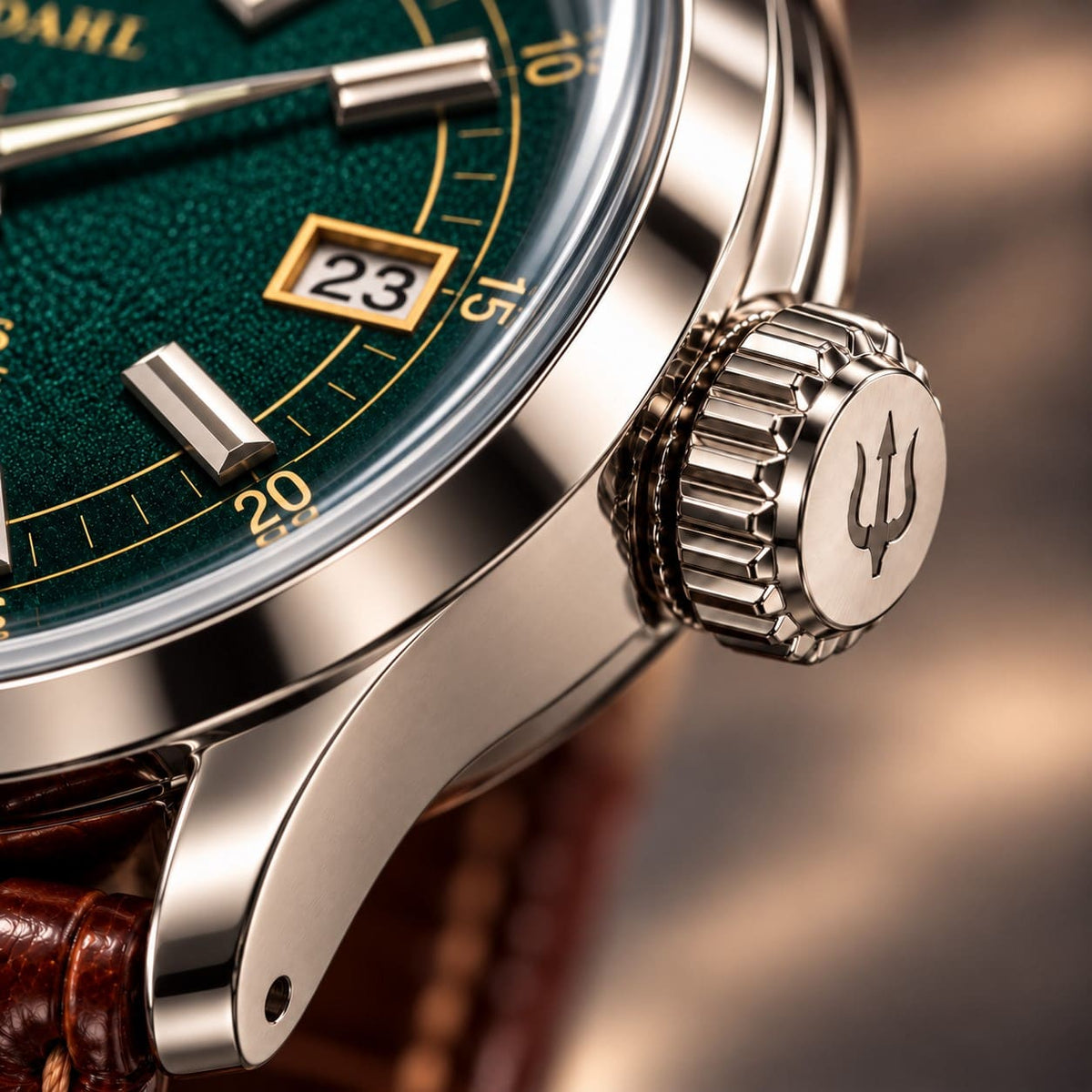 Close-up of the grooved steel crown with engraved trident on SANDAHL ORNATUS Malachite, beside the green dial and polished case.