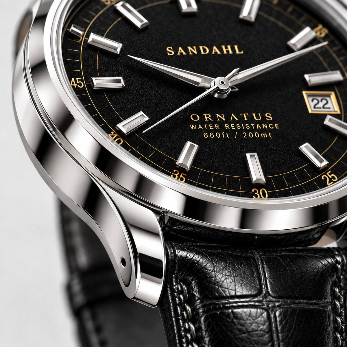 Close-up of the polished steel case and rounded lugs of SANDAHL ORNATUS Onyx, with a black dial and black leather strap.