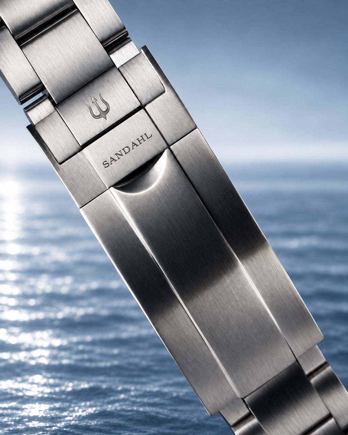 Close-up of a SANDAHL SHALLOW steel bracelet clasp engraved with SANDAHL and the trident.