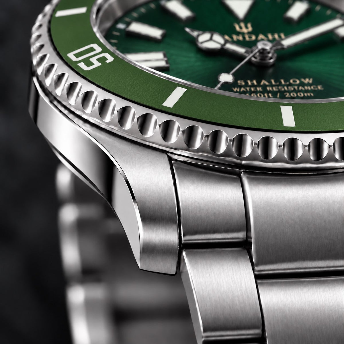 Macro view of the SANDAHL SHALLOW Archipelago Green steel case and bracelet, with a green dive bezel and green dial.