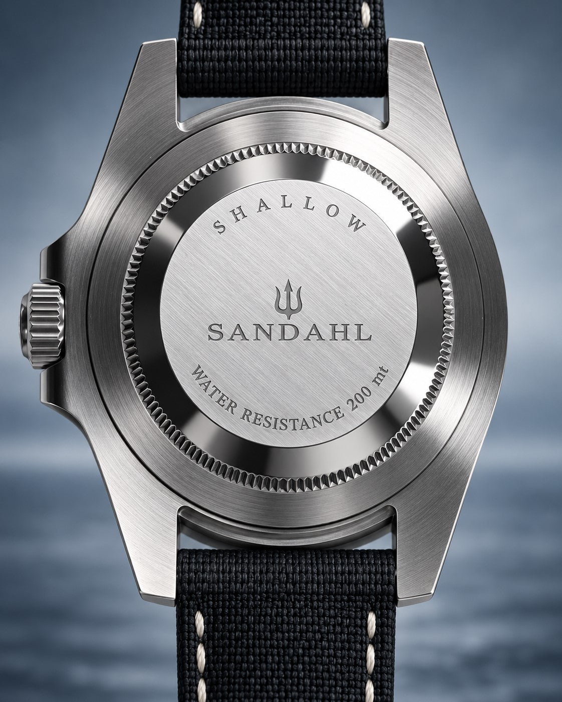 Rear view of a SANDAHL SHALLOW watch with its engraved steel caseback and black stitched fabric strap.