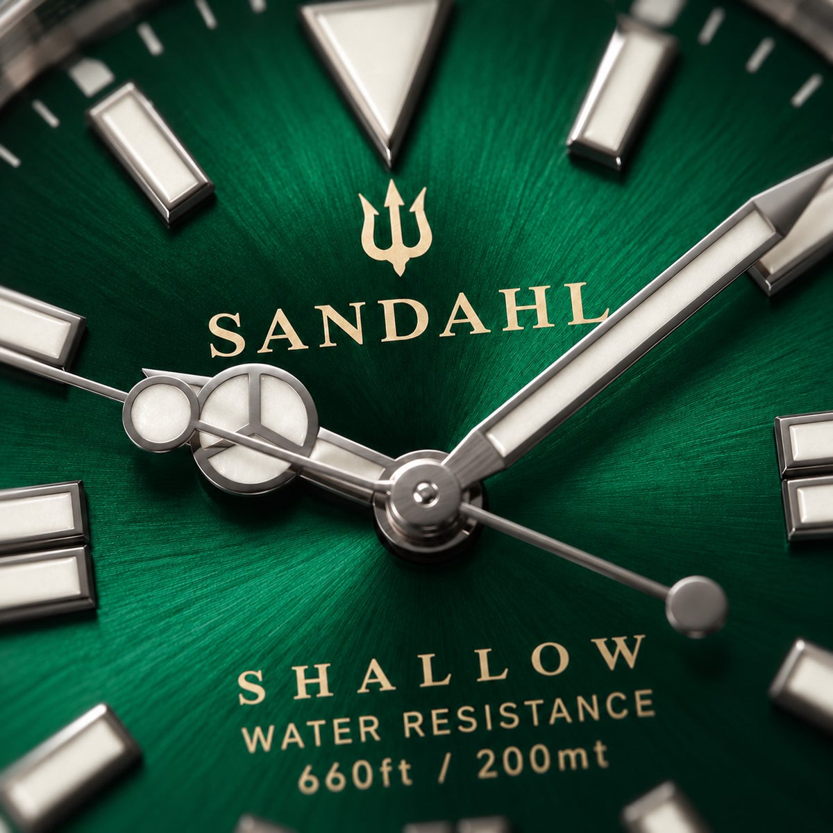 Macro detail of the green dial on the SANDAHL SHALLOW Archipelago Green, featuring LumiSand hour markers and hands.