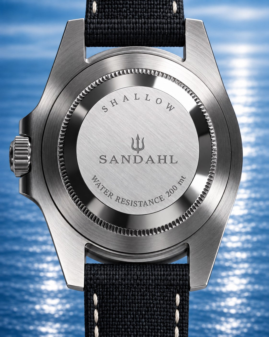 Rear view of a SANDAHL SHALLOW watch with its engraved steel caseback and black stitched fabric strap.