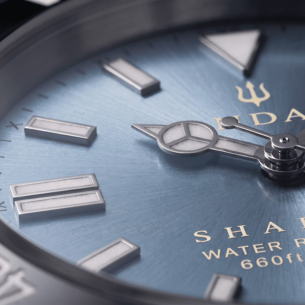 Macro detail of the light blue dial on the SANDAHL SHALLOW Glacial Blue, featuring LumiSand hour markers and hands.
