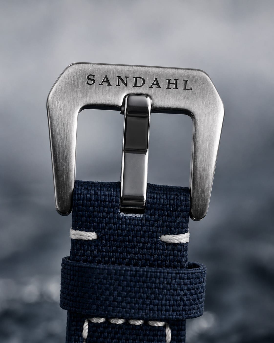 Close-up of the engraved steel buckle and stitched fabric strap on SANDAHL SHALLOW Kattegatt Blue.