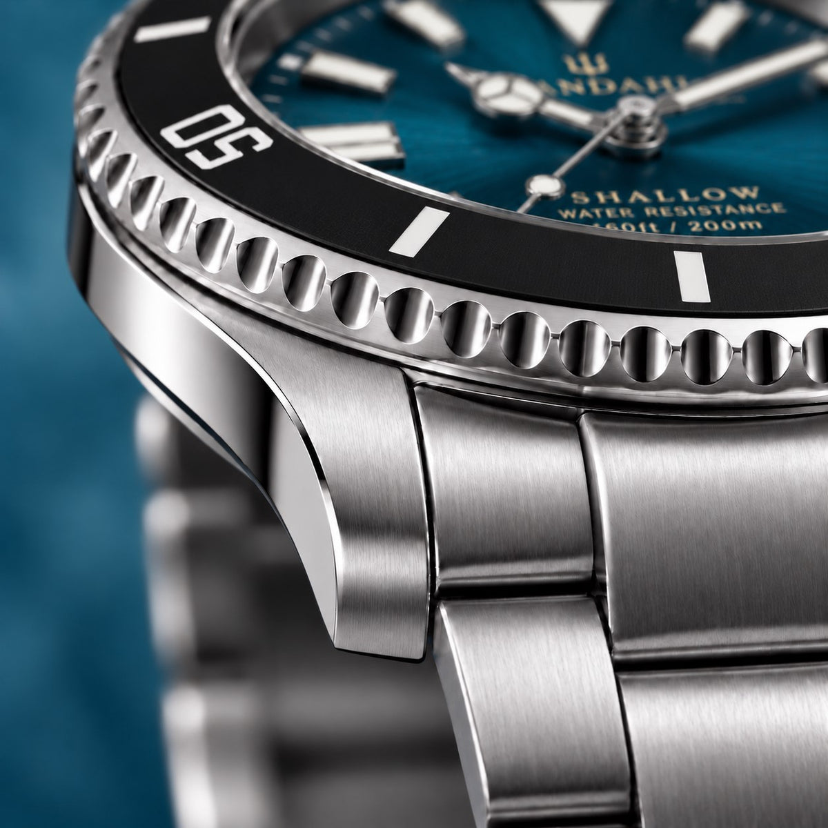 Macro view of the SANDAHL SHALLOW Skagerrak Teal steel case and bracelet, with a black dive bezel and teal dial.