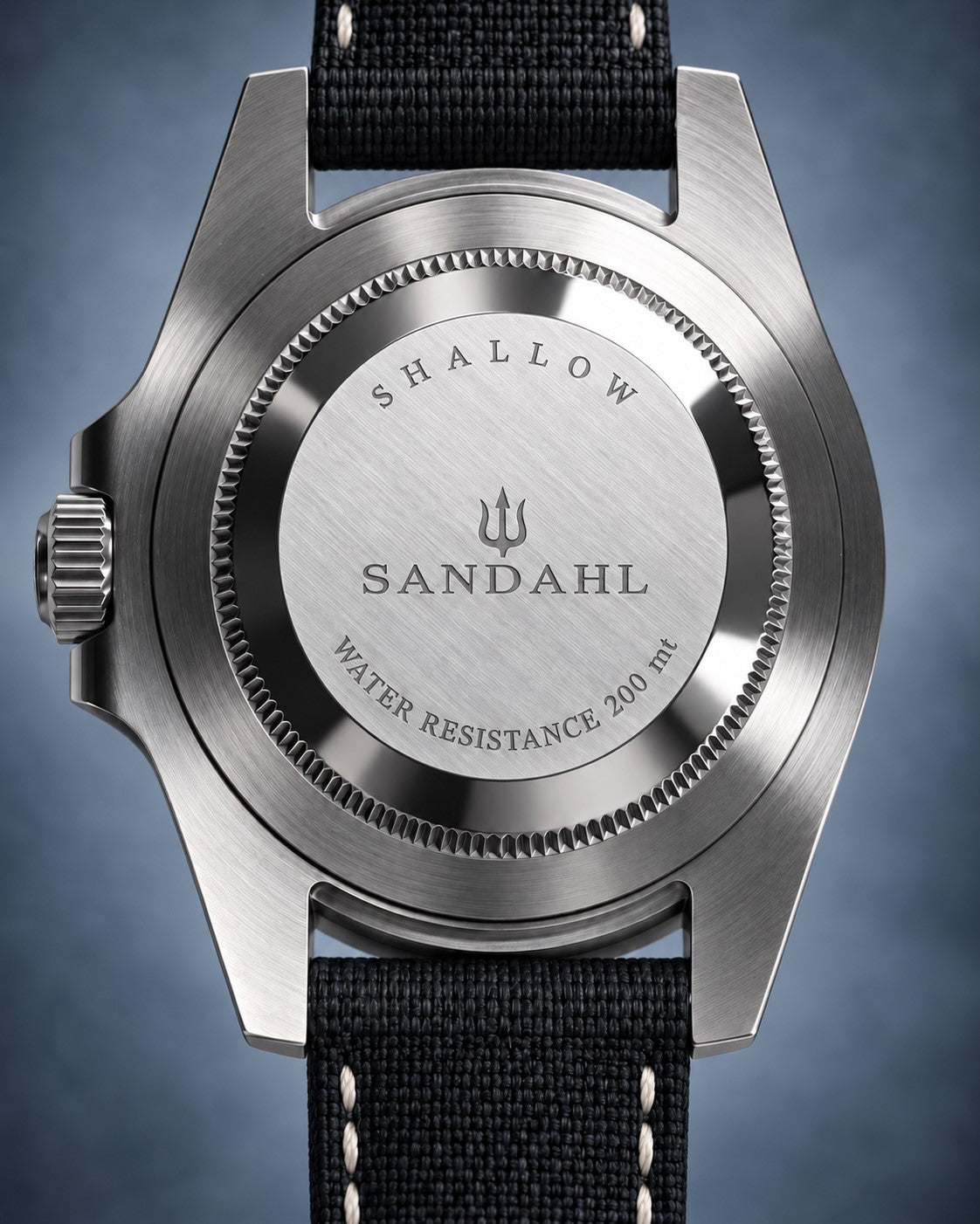 Rear view of a SANDAHL SHALLOW watch with its engraved steel caseback and black stitched fabric strap.