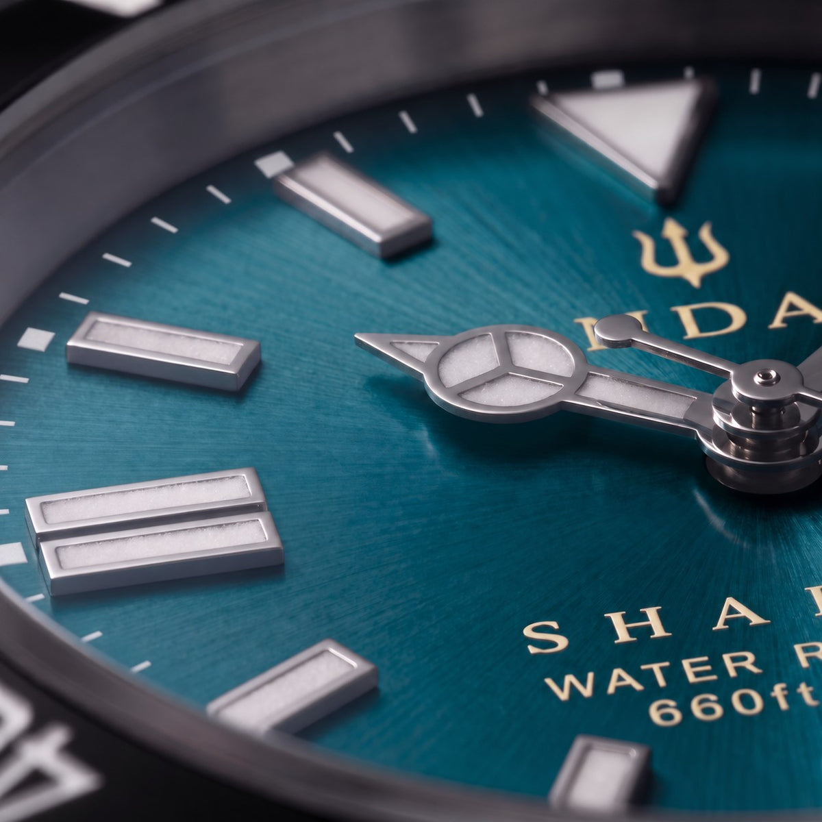 Macro detail of the teal dial on the SANDAHL SHALLOW Skagerrak Teal, featuring LumiSand hour markers and hands.