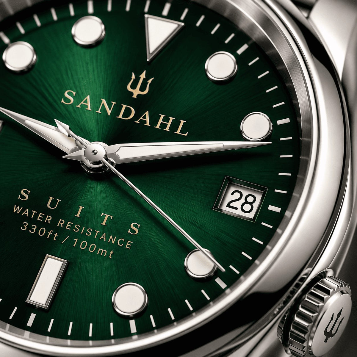 Close-up of the green sunburst SUITS dial, luminous markers, polished hands, date window and trident crown.