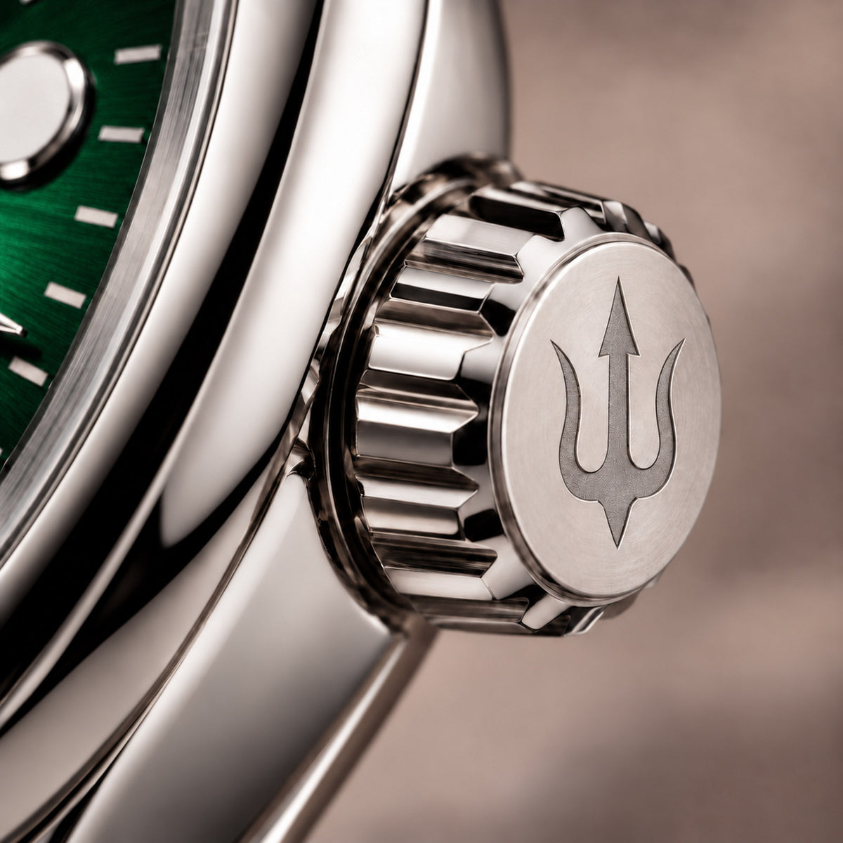 Close-up of the SUITS Regent Green stainless steel crown with its engraved trident, fluted edges and green dial.