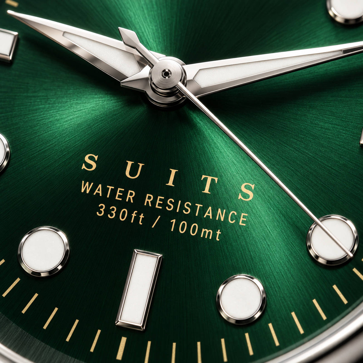 Extreme close-up of the SANDAHL SUITS Regent Green dial, showing its emerald sunburst texture, gold lettering and polished hands and hour markers.