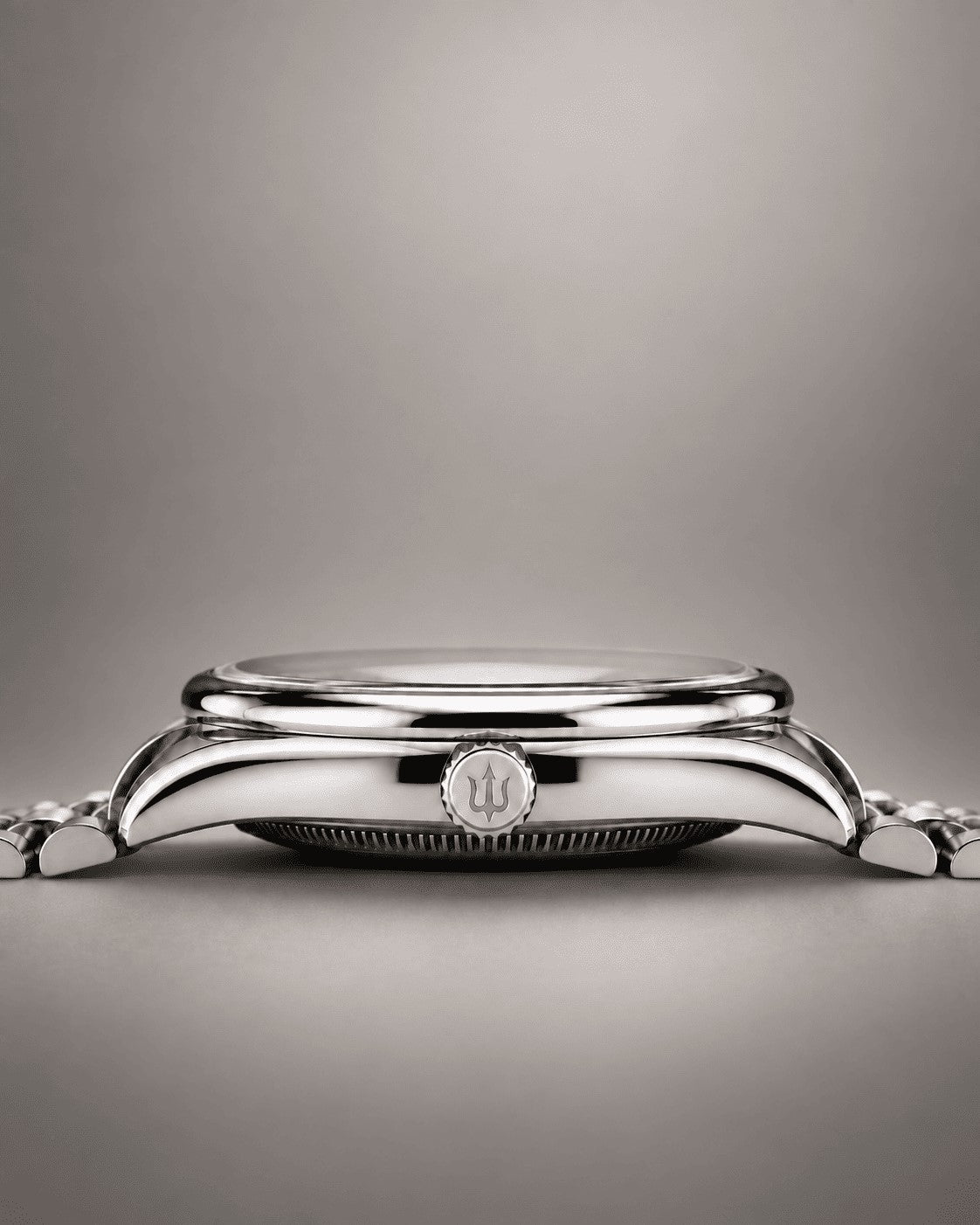 Side profile of a SANDAHL SUITS watch, showing the polished steel case, rounded bezel and trident-engraved crown.