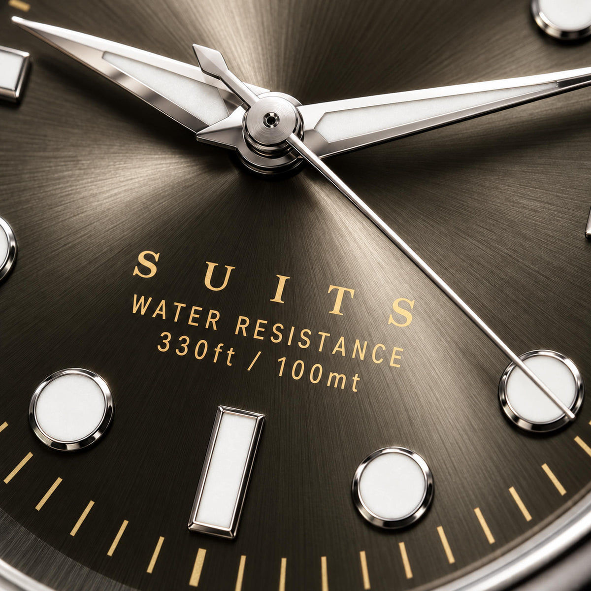 Extreme close-up of the SANDAHL SUITS Savile Taupe dial, showing its taupe sunburst texture, gold lettering and polished hands and hour markers.